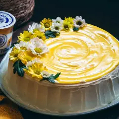Torta con glassa gialla e fiori, un tripudio di freschezza che ricorda il sapore del lemon curd.