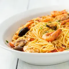 Un invitante piatto di spaghetti allo scoglio, ricco di gamberi, cozze e vongole, pronto per essere gustato.