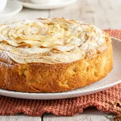 Una deliziosa torta di mele senza burro, decorata con fettine di mela e zucchero a velo, pronta per essere gustata.