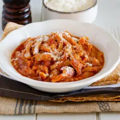Un invitante piatto di trippa alla parmigiana, cosparso di formaggio grattugiato, pronto per essere gustato.