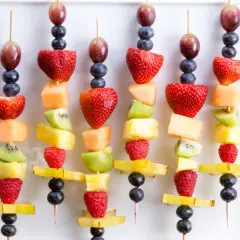 Spiedini di frutta colorati, perfetti per idee fresche e golose. Fragole, kiwi, melone e mirtilli su stecchini.