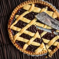 Una deliziosa crostata di more, con la sua croccante pasta frolla e un ripieno succoso, pronta per essere gustata.