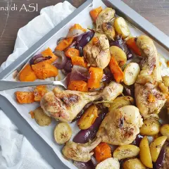Pollo al forno con patate, zucca e cipolle rosse, un piatto saporito e colorato pronto per essere gustato.