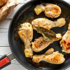 Fusi di pollo succulenti e dorati in padella, con rosmarino e alloro. Accompagnati da panini integrali.
