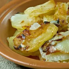 Patate alla lionese dorate e croccanti, servite in una ciotola di terracotta. Un classico saporito.