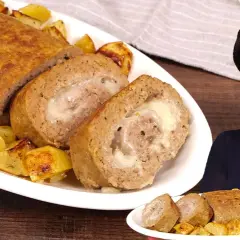 Un succulento polpettone al forno, ripieno di formaggio filante, servito con patate arrosto.