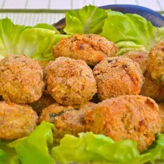 Polpette di melanzane fritte dorate e croccanti, servite su un letto di lattuga fresca.