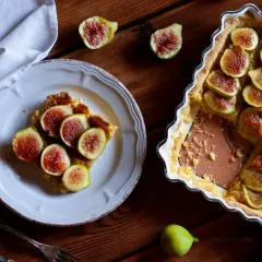 Deliziosi dolci con fichi freschi, una fetta su un piatto bianco e la torta intera in una teglia.