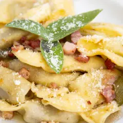 Un piatto di casoncelli alla bergamasca, conditi con burro, salvia e pancetta croccante, spolverati di parmigiano.