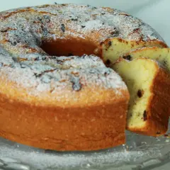 Ciambellone soffice con tante gocce di cioccolato, spolverato di zucchero a velo, pronto per essere gustato.