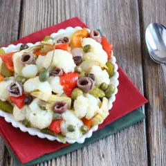 Insalata di rinforzo con cavolfiore, peperoni, acciughe e capperi, un piatto saporito e colorato.
