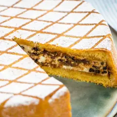 Una fetta di cassata al forno, con glassa a rombi e ripieno cremoso, pronta per essere gustata.