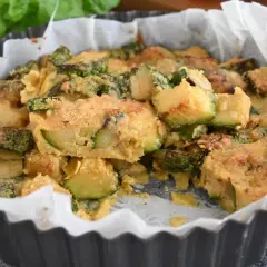 Deliziosi zucchine al forno, dorati e fragranti, in una tortiera foderata di carta forno.