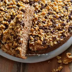 Torta di noci della nonna, soffice e golosa, ricoperta di noci tritate e gocce di cioccolato. Un classico intramontabile.