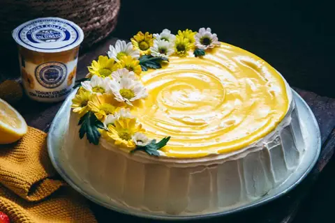 Torta con glassa gialla e fiori, un tripudio di freschezza che ricorda il sapore del lemon curd.