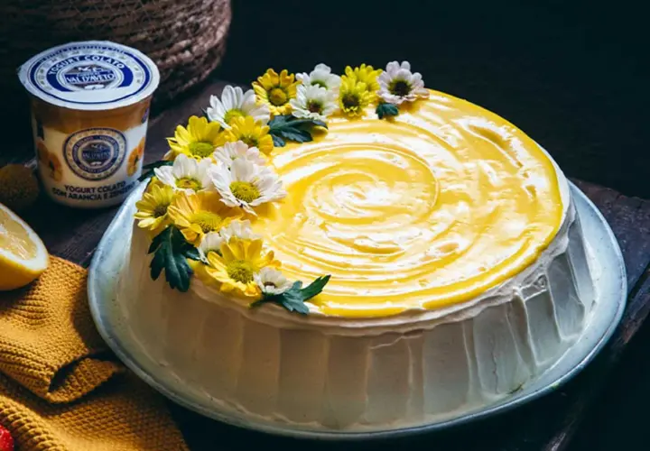 Torta con glassa gialla e fiori, un tripudio di freschezza che ricorda il sapore del lemon curd.