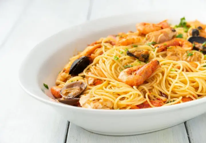 Un invitante piatto di spaghetti allo scoglio, ricco di gamberi, cozze e vongole, pronto per essere gustato.