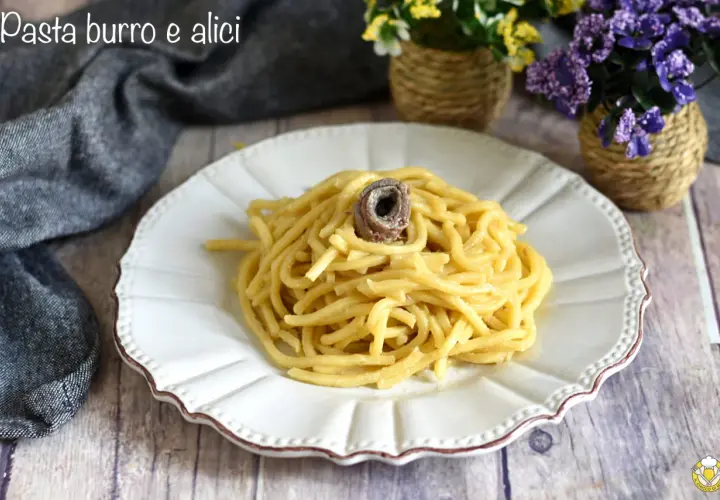Un piatto di pasta burro e alici, semplice e gustoso, con un'alice arrotolata in cima.