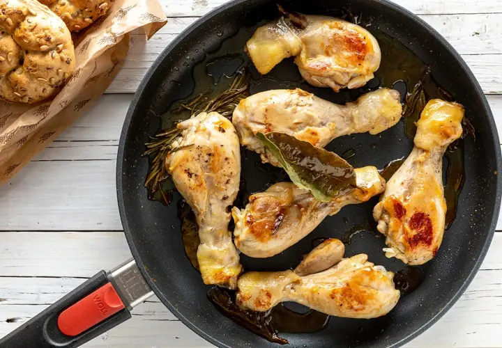 Fusi di pollo succulenti e dorati in padella, con rosmarino e alloro. Accompagnati da panini integrali.