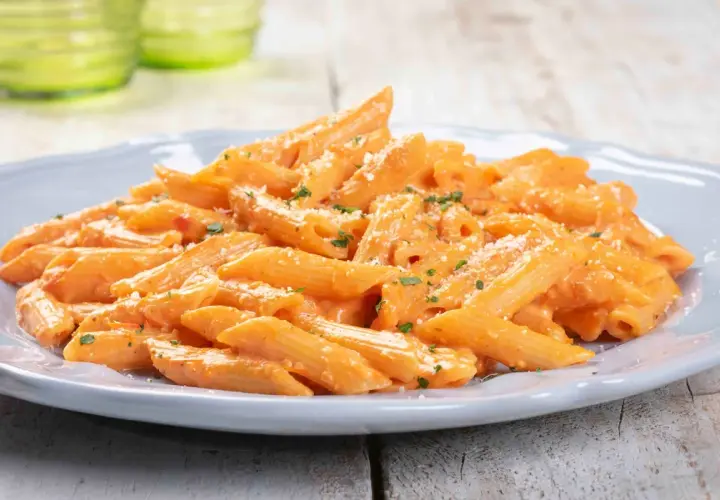 Penne cremose con salsa rosa, un'idea perfetta per primi piatti veloci e gustosi. Spolverata di parmigiano e prezzemolo fresco.