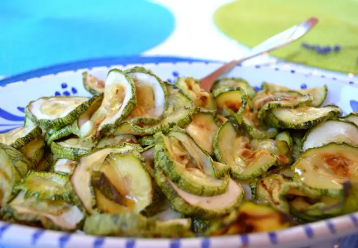 Fette di zucchine in carpione, condite con olio e aceto, pronte per essere gustate.