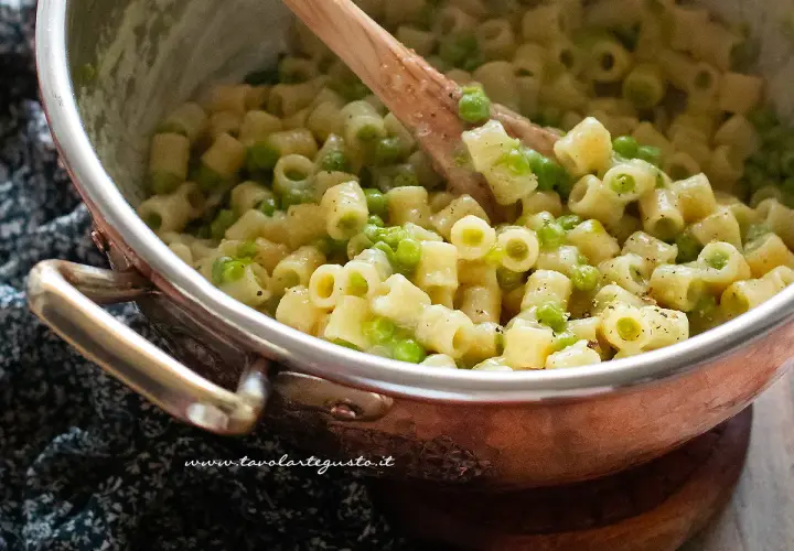 Un primo piatto cremoso di pasta e piselli, pronto per essere gustato.