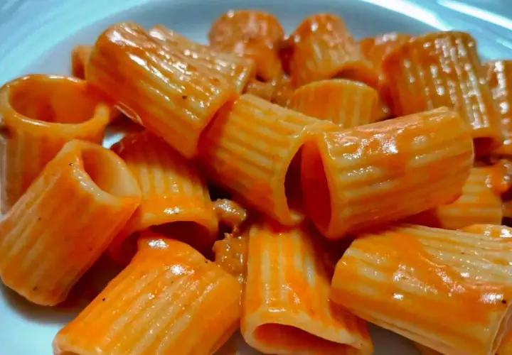 Rigatoni conditi con un sugo rosso cremoso, un piatto che ricorda la pasta alla carcerata, ricco e saporito.