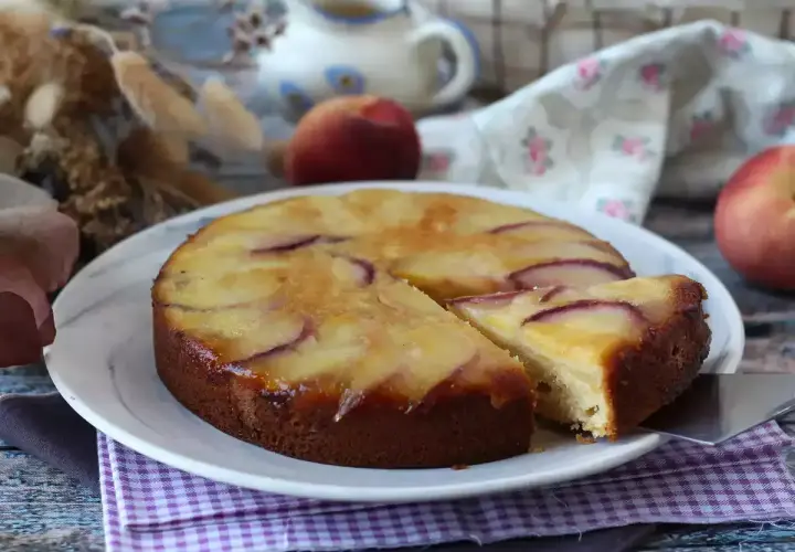 Deliziosa torta di pesche rovesciata, con fette dorate e succose che invitano ad assaggiare.