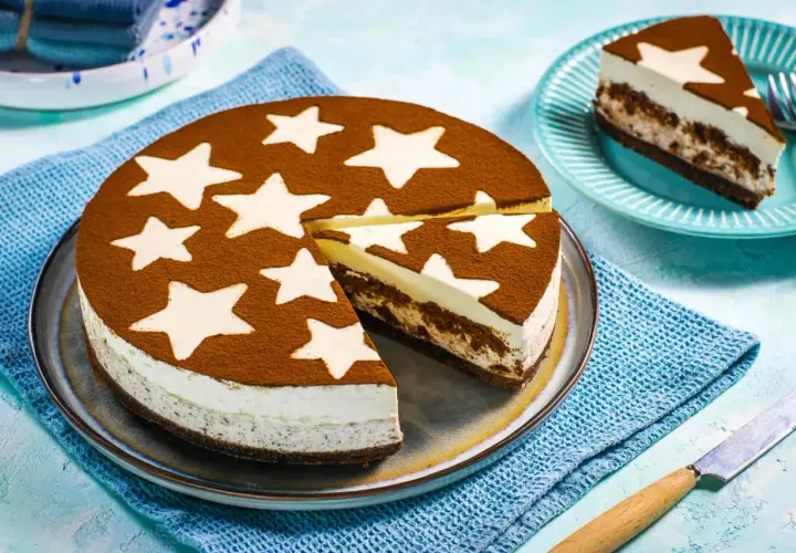 Una deliziosa torta pan di stelle fredda, con una base scura e strati cremosi, decorata con cacao e stelle bianche. Perfetta per un momento magico.