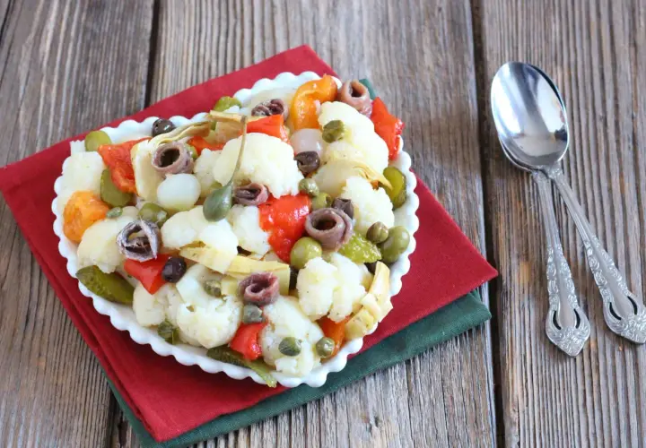 Insalata di rinforzo con cavolfiore, peperoni, acciughe e capperi, un piatto saporito e colorato.
