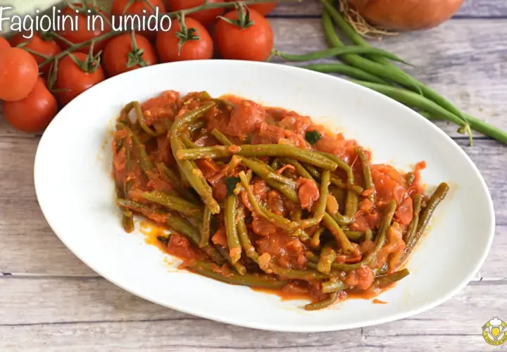 Fagiolini in umido, un piatto saporito con fagiolini verdi cotti in un sugo di pomodoro e cipolla, accompagnato da pomodorini freschi.