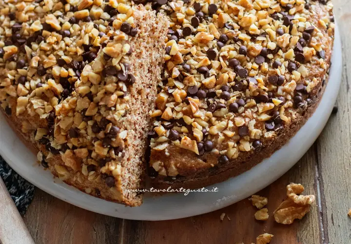 Torta di noci della nonna, soffice e golosa, ricoperta di noci tritate e gocce di cioccolato. Un classico intramontabile.