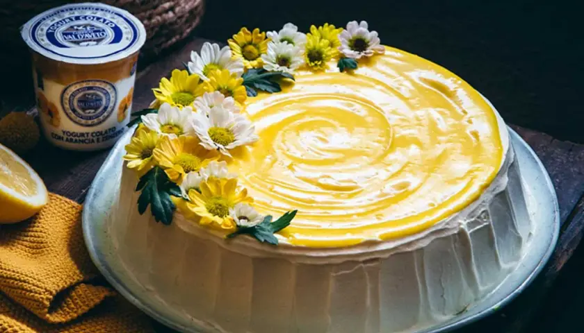 Torta con glassa gialla e fiori, un tripudio di freschezza che ricorda il sapore del lemon curd.