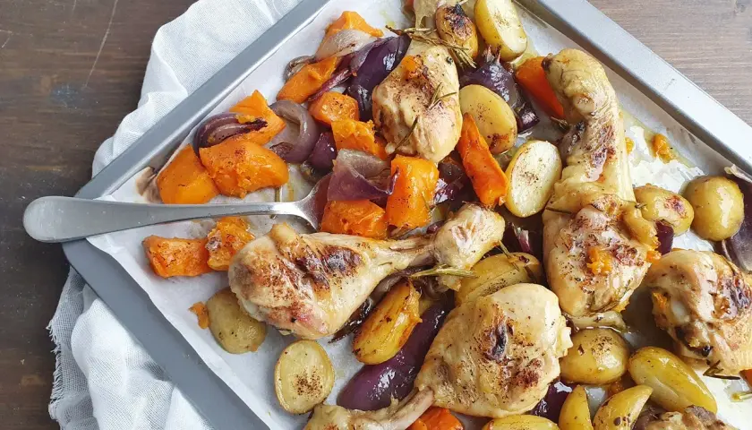 Pollo al forno con patate, zucca e cipolle rosse, un piatto saporito e colorato pronto per essere gustato.