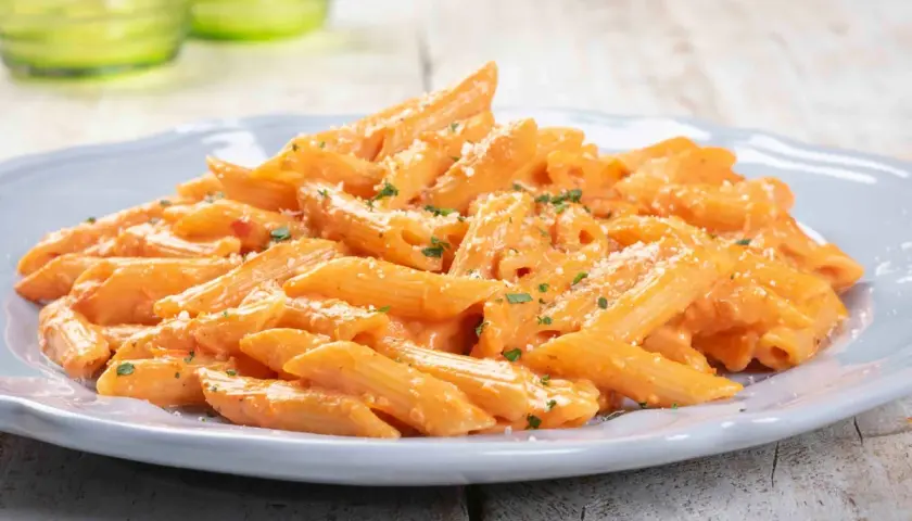 Penne cremose con salsa rosa, un'idea perfetta per primi piatti veloci e gustosi. Spolverata di parmigiano e prezzemolo fresco.