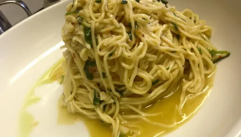 Spaghetti aglio olio e peperoncino cremosi, un piatto semplice ma ricco di sapore, con un filo d'olio dorato che invita al primo assaggio.