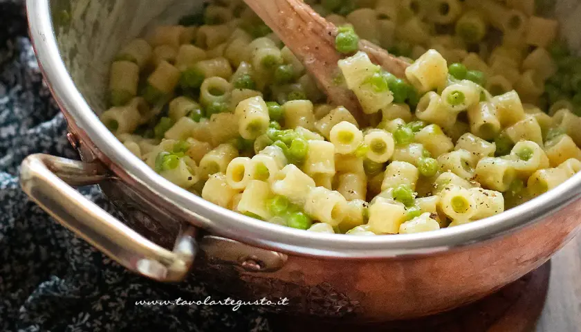 Un primo piatto cremoso di pasta e piselli, pronto per essere gustato.