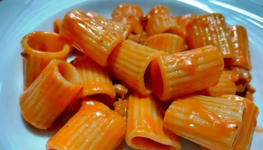 Rigatoni conditi con un sugo rosso cremoso, un piatto che ricorda la pasta alla carcerata, ricco e saporito.
