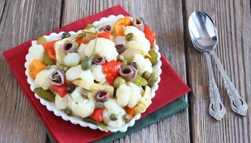 Insalata di rinforzo con cavolfiore, peperoni, acciughe e capperi, un piatto saporito e colorato.