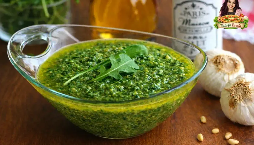 Pesto di rucola Bimby pronto in ciotola, con rucola fresca, pinoli e aglio. Un condimento saporito e facile da preparare.