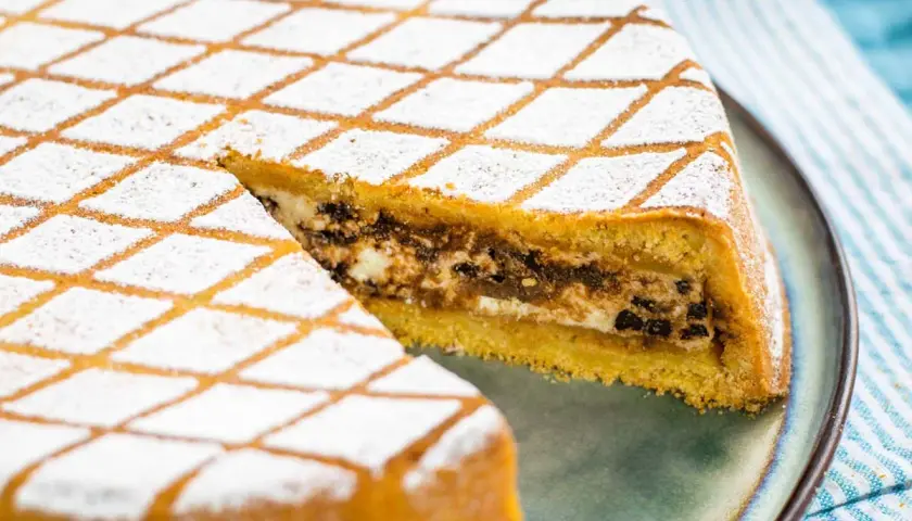 Una fetta di cassata al forno, con glassa a rombi e ripieno cremoso, pronta per essere gustata.