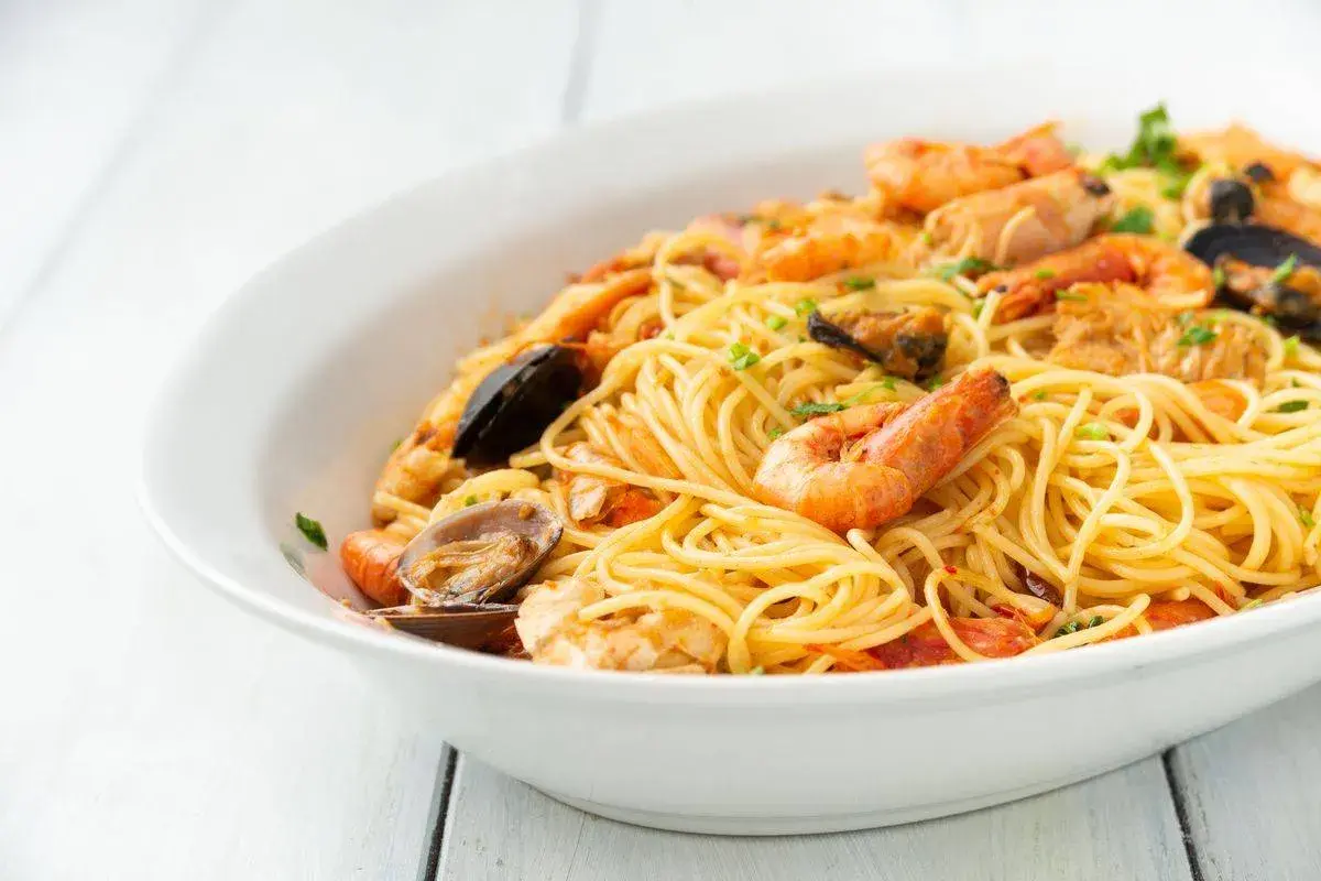 Un invitante piatto di spaghetti allo scoglio, ricco di gamberi, cozze e vongole, pronto per essere gustato.