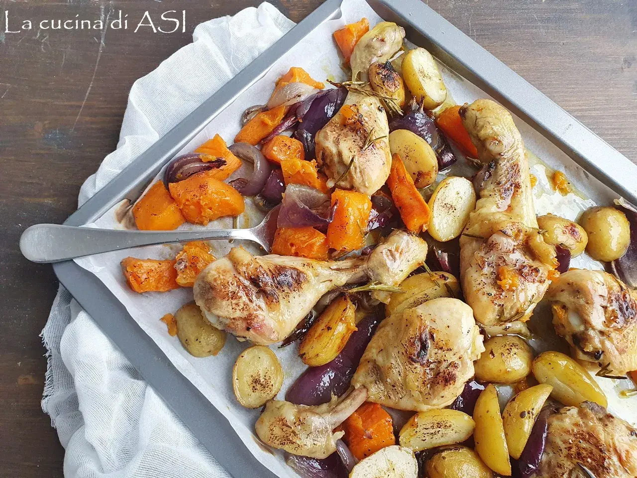 Pollo al forno con patate, zucca e cipolle rosse, un piatto saporito e colorato pronto per essere gustato.