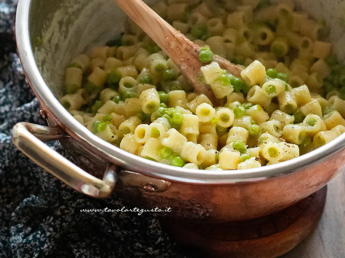 Un primo piatto cremoso di pasta e piselli, pronto per essere gustato.