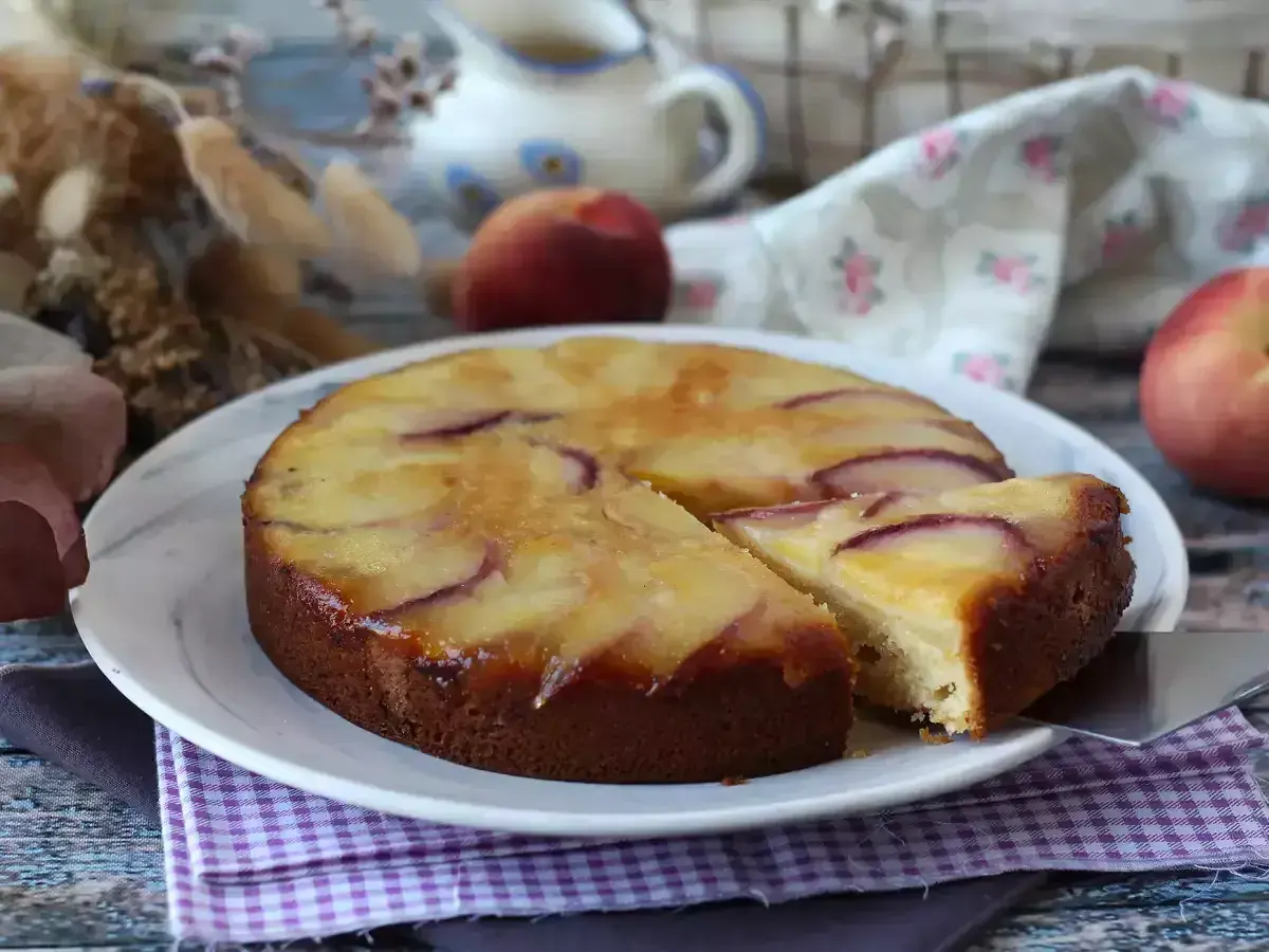 Deliziosa torta di pesche rovesciata, con fette dorate e succose che invitano ad assaggiare.