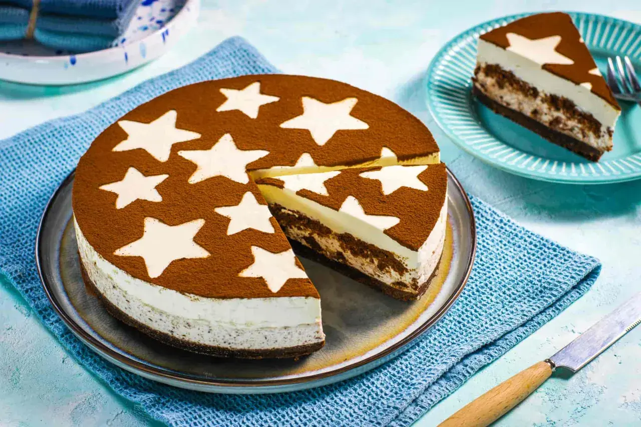 Una deliziosa torta pan di stelle fredda, con una base scura e strati cremosi, decorata con cacao e stelle bianche. Perfetta per un momento magico.