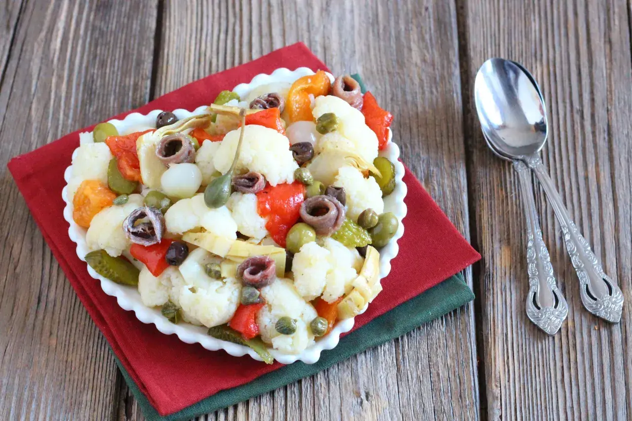 Insalata di rinforzo con cavolfiore, peperoni, acciughe e capperi, un piatto saporito e colorato.
