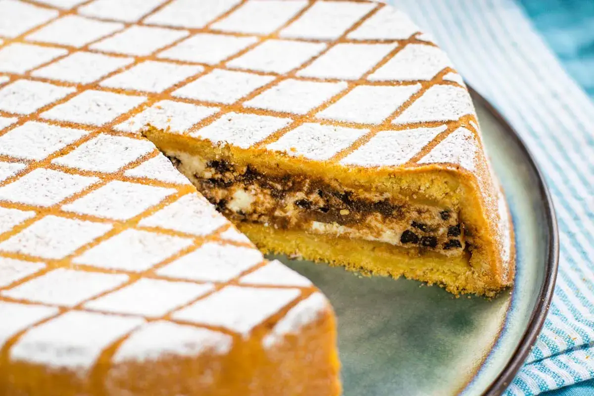 Una fetta di cassata al forno, con glassa a rombi e ripieno cremoso, pronta per essere gustata.