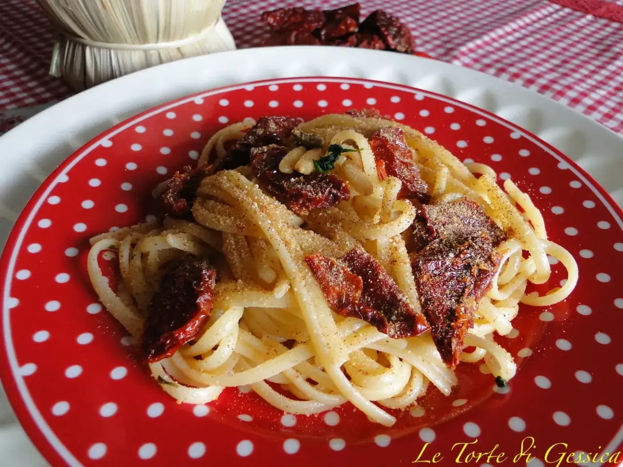 Un piatto di spaghetti con pomodori secchi e mollica tostata, un classico saporito.