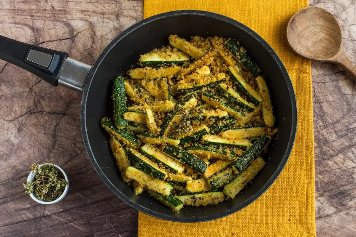 Zucchine tagliate a bastoncino, impanate e cotte in padella. Un delizioso contorno di verdure pronto per essere gustato.